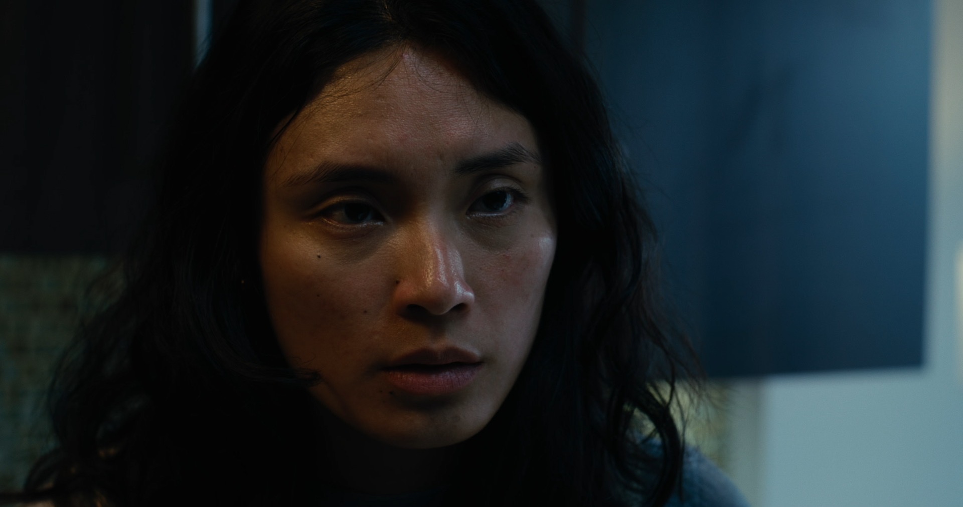 Close-up of a woman at the table, looking off camera.