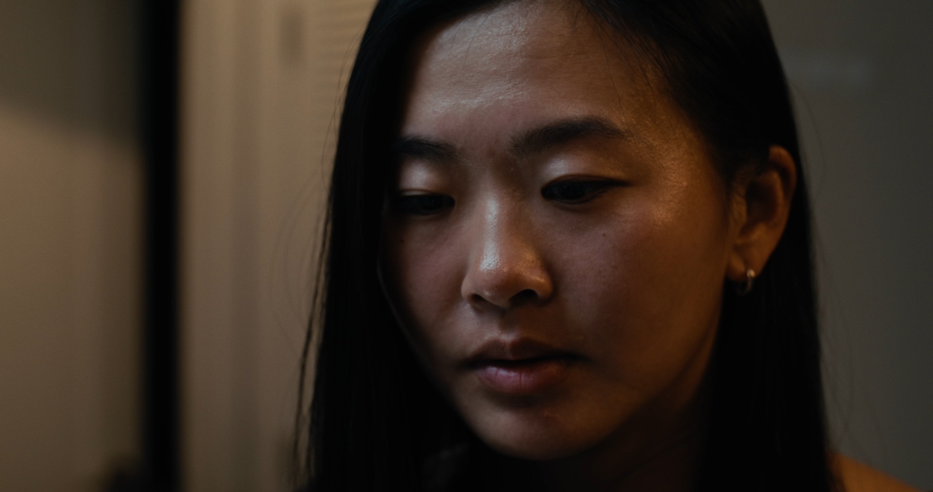 Close-up of the other woman, eyes lowered.